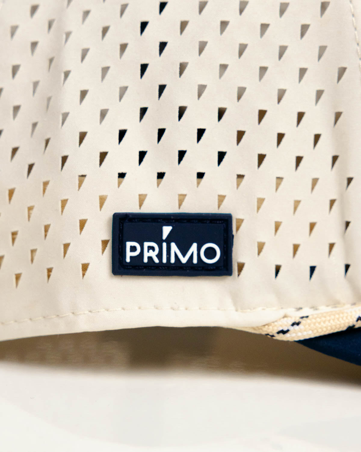 Primo Golf Hat Cream Navy — perforated side panel with Primo rubber patch